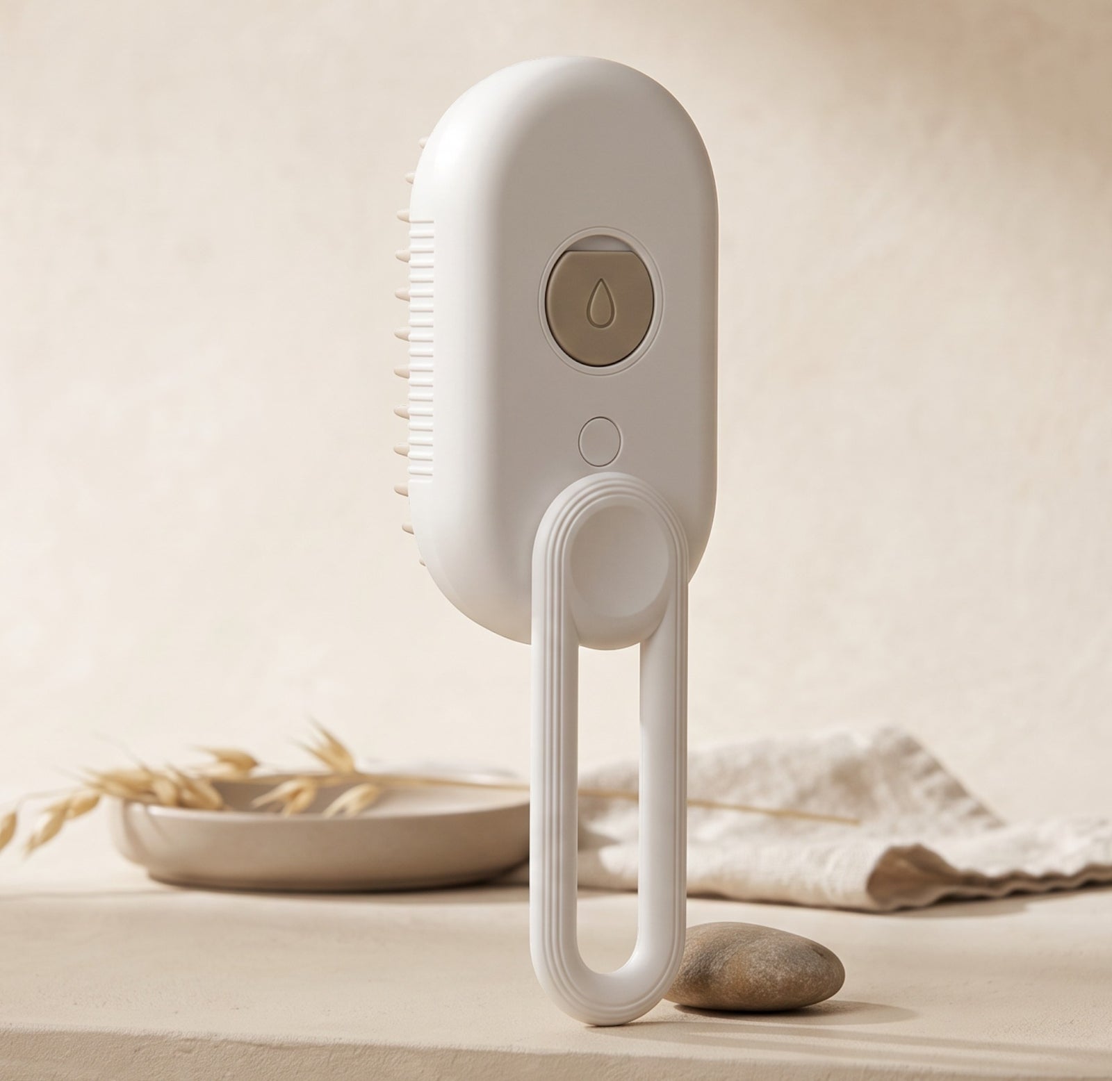 Nuzzo 3-in-1 electric pet spa brush in white with misting button, massage bristles, and a hanging loop.