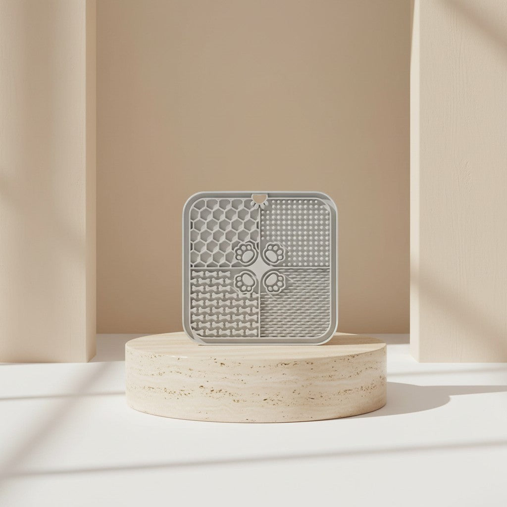Nuzzo grey silicone slow feed dog lick mat with textured patterns on a stone pedestal for pet enrichment