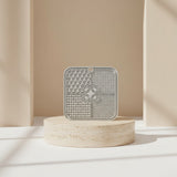Nuzzo grey silicone slow feed dog lick mat with textured patterns on a stone pedestal for pet enrichment