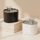 Nuzzo PureFlow smart pet water fountains in black and white, featuring a modern design on stone pedestals.