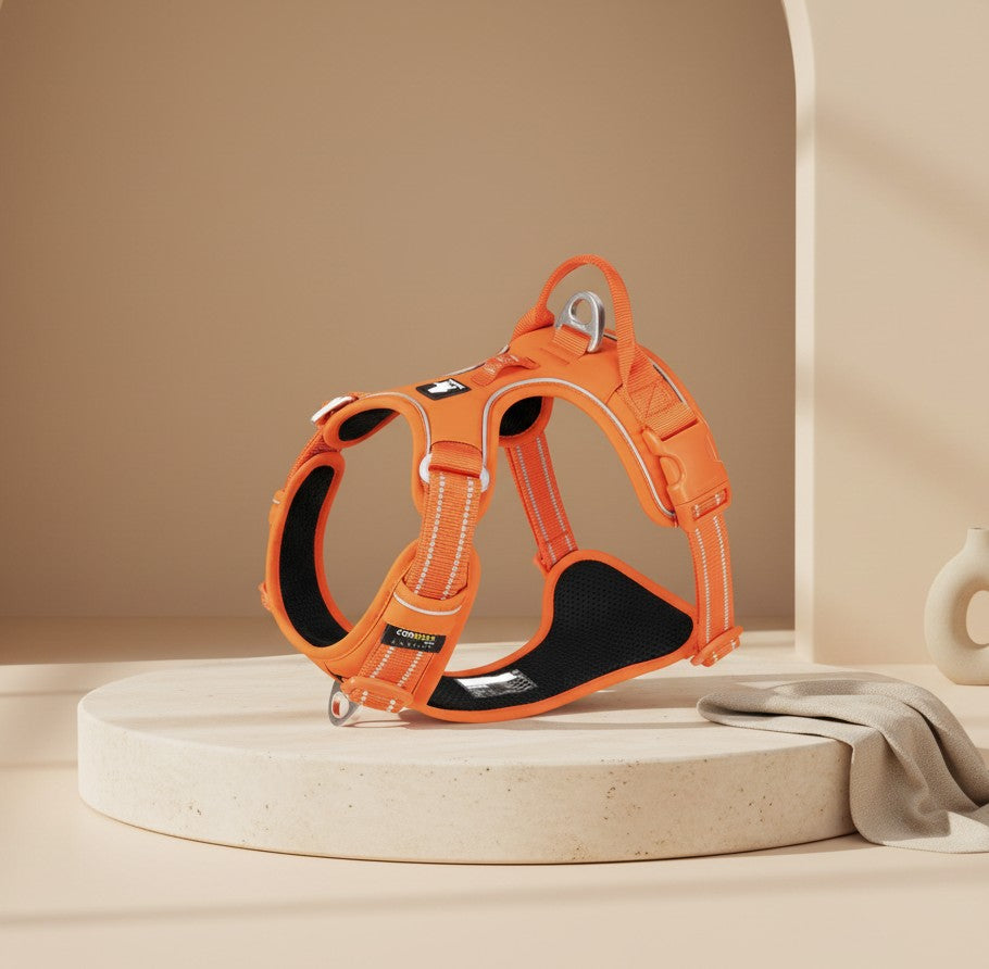 Nuzzo ReflectPro orange dog harness with reflective stitching and soft padded chest on a beige display pedestal.