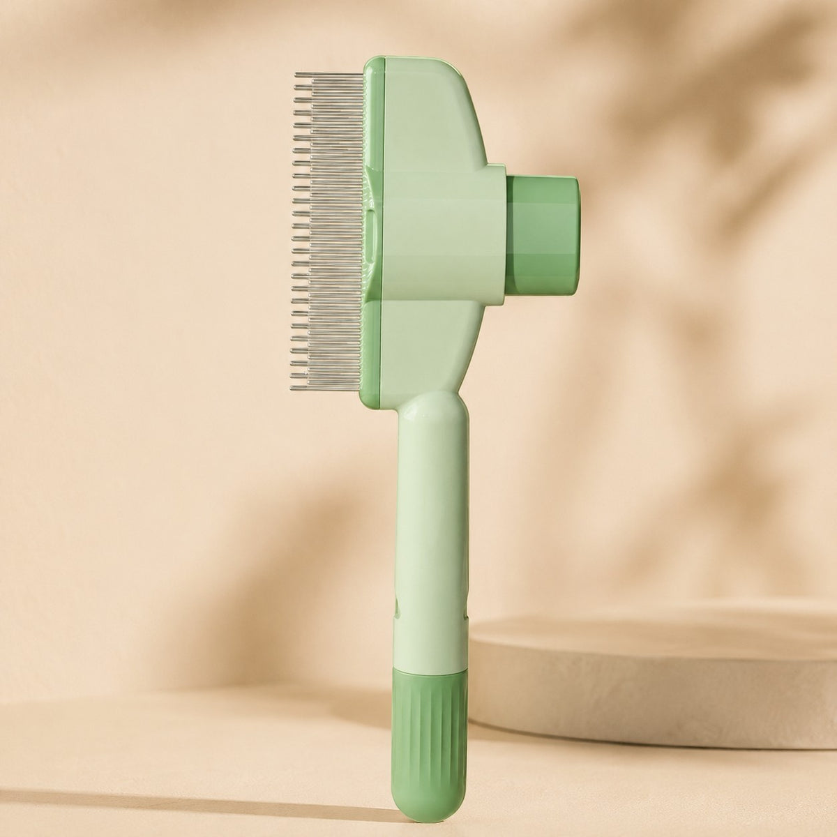 Nuzzo self-cleaning pet hair comb in light green with stainless steel teeth and a one-click fur release button