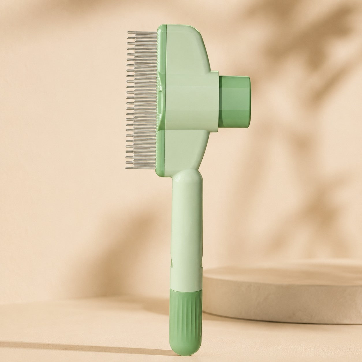 Nuzzo self-cleaning pet hair comb in light green with stainless steel teeth and a one-click fur release button