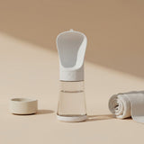 Nuzzo white 2-in-1 portable dog water bottle with integrated drinking bowl on a neutral beige background